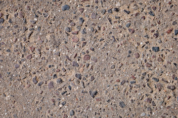 Close up of brown asphalt with colored stones. Rough surface. Abstract textured background