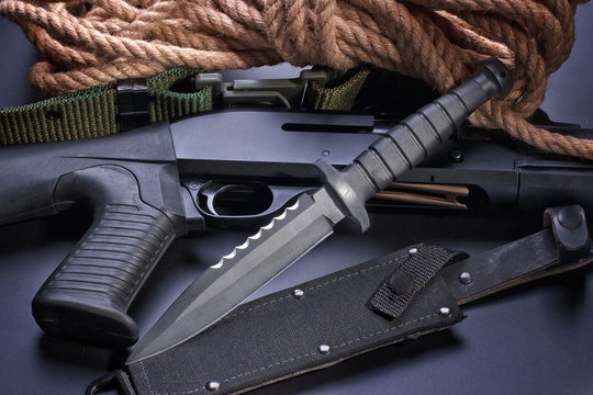 Knife and pump gun on black background
