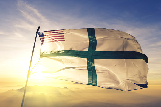 Sinoe county of Liberia flag waving on the top sunrise mist fog