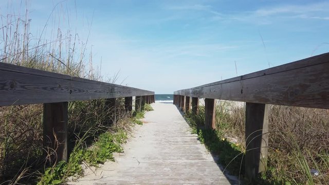 A slow motion view walking towards a sandy beach.  	