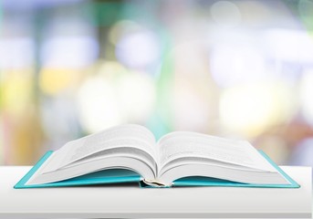 Stack of books with laptop on table