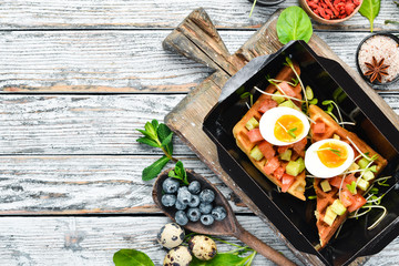 savory waffles with avocado, tomatoes and egg. Delivery of food. Dietary nutrition. Top view. Free copy space.