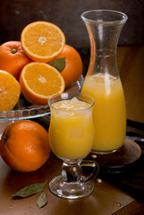 glass of fresh orange juice with fresh fruits on wooden