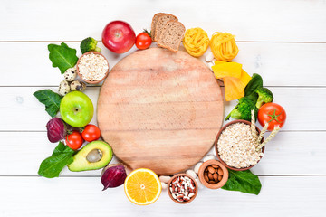 Concept of healthy food: bread, pasta, avocado, flour, pumpkin, broccoli, beans, spinach. Vegetables and fruits. Top view. Free copy space.