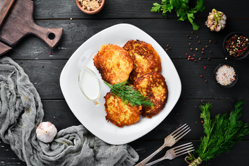 Potato pancakes with sour cream. Ukrainian Traditional Cuisine. Top view. Free space for your text. Rustic style.