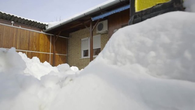 Man chopping wood in snow yard winter village