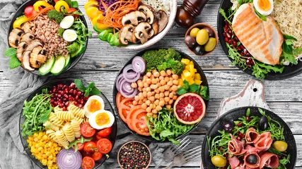 Fotobehang Boeddha Boeddha kom op een witte houten achtergrond. Assortiment van gezonde voeding. Bovenaanzicht. Vrije ruimte voor uw tekst.  © Yaruniv-Studio