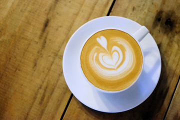 Cups of cafe latte on wooden table background