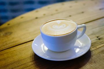 Cups of cafe latte on wooden table background