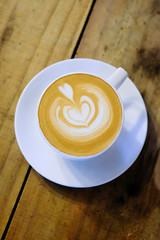 Cups of cafe latte on wooden table background