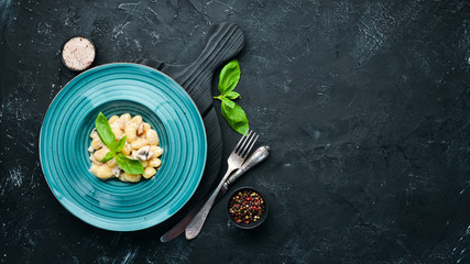 Gnocci In the plate. Italian Traditional Cuisine. Potato dumplings. Top view. Free space for your text. Rustic style.