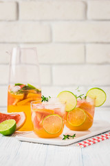 Refreshing iced citrus mocktail on light blue background. Selective focus, space for text.