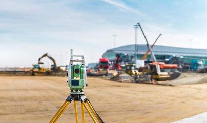 Surveyor engineer with equipment (theodolite or total positioning station) on the construction site...