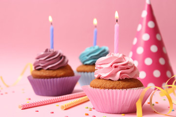 Delicious cupcakes with candles on a colored background. Festive background, birthday