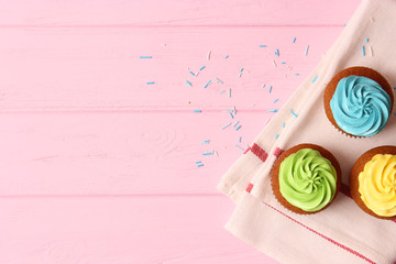 Tasty cupcakes on the wooden table.
