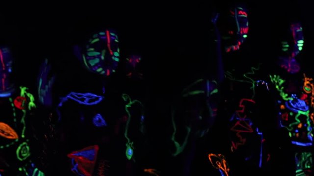 Children in neon light, girl with fluorescent make-up, Art design of female disco dancer dancing in UV light, colorful make up. Slow motion