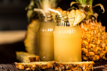 Pineapple juice and slice placed on a wooden table