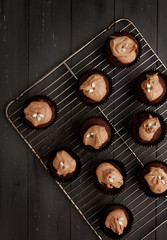 Fairy cakes on a cooling tray on a distressed grey wooden background