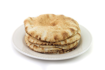 Pita bread isolated on white background in ceramic dish. Traditional food of Arabic cuisine