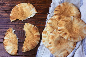 Pita bread isolated on rustic wooden table on rustic cloth. Traditional food of Arabic cuisine