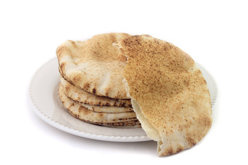 Pita bread isolated on white background in ceramic dish. Traditional food of Arabic cuisine