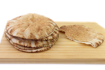 Pita bread isolated on white background in wooden spatula. Traditional food of Arabic cuisine