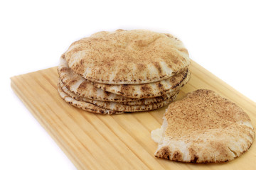 Pita bread isolated on white background in wooden spatula. Traditional food of Arabic cuisine