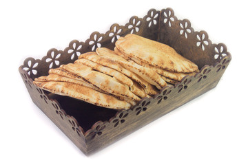 Pita bread isolated on white background in the breakfast basket. Traditional food of Arabic cuisine
