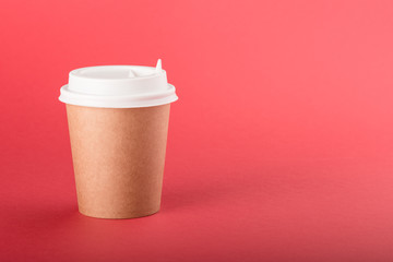 Kraft disposable cup with white cap on a red background