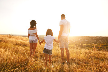 Happy family on nature in summer at sunset.