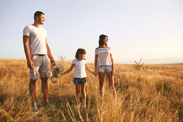 Happy family playing on nature in summer at sunset.