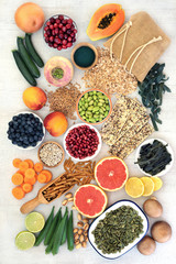 High fibre food for good health with fruit, vegetables, seeds, nuts, cereals and whole wheat pasta. Full of antioxidants, anthocyanins, vitamins and omega 3. Top view on rustic background.