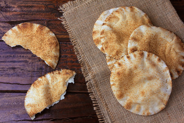 Pita bread isolated on rustic wooden table on rustic cloth. Traditional food of Arabic cuisine