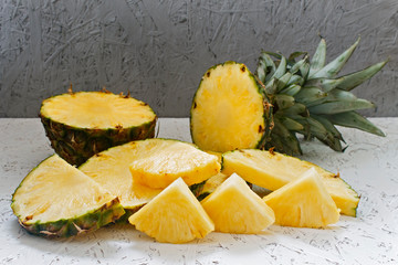 Sliced pineapple on white wooden background. Pineapple Slices of Different Sizes