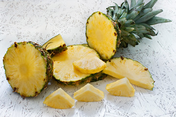 Sliced pineapple on white wooden background. Pineapple Slices of Different Sizes