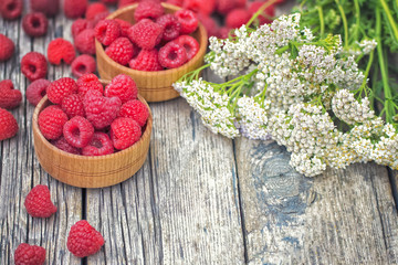 summer background with raspberry berries and a bouquet of wild flowers. raspberry berries on wooden background. raspberry close-up.