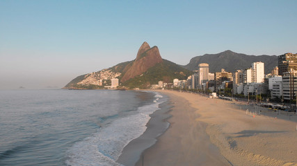 Sunrise over Leblon beach in Rio de Janeiro. Early morning deserted city coastline.