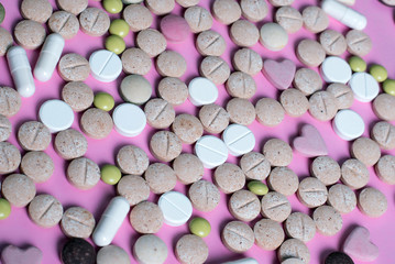 harmaceuticals antibiotics pills medicine /colorful antibacterials pills on pink background /capsule pill medicine. Creative idea. Drugs. Sad. Die. Illness