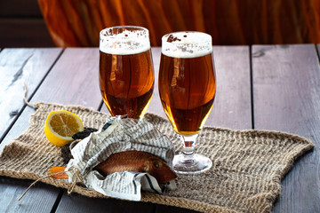 glass of beer and chips on wooden table