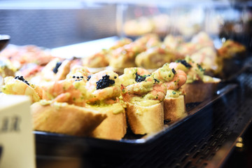 Tapas on Crusty Bread - Selection of Spanish tapas served on a sliced baguette.