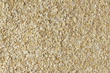 Dry rolled oatmeal flakes as background top view