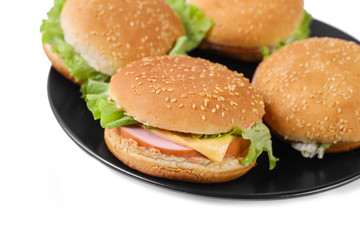 Hamburger with sausage and cheese with fresh lettuce. Four hamburgers on black plate. Isolated. Top view