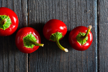 cherry peppers on old black wooden table background