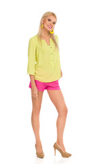Smiling Beautiful Blond Woman In Vibrant Clothes And High Hells Is Standing And Looking At Camera