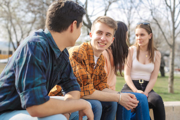 Friends sitting in a park, chatting and laughing