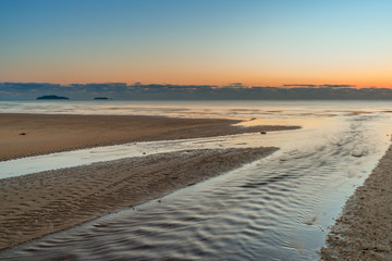 Lichtstimmung zum Sonnenaufgang am Strand von Kurrimine Beach in Queensland Australien