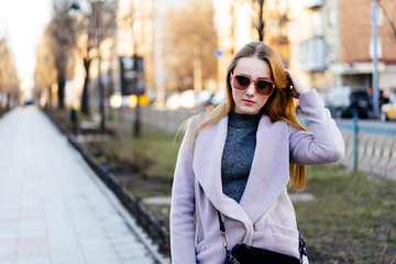 Beautiful young caucasian woman walking along the street in the city. Stylish female model running...