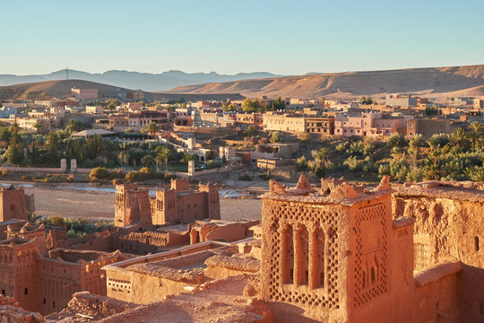 From above old town with stone constructions near narrow river between desert and beautiful heaven with clouds in Marrakesh, Morocco