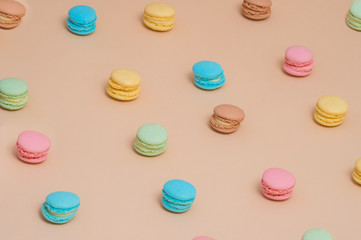 Colorful cake macaron or macaroon on cream pastel background from above. French almond cookies on dessert top view.