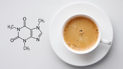 Cup of fresh coffee on white background. Blackboard with the chemical formula of Caffeine. Top view...